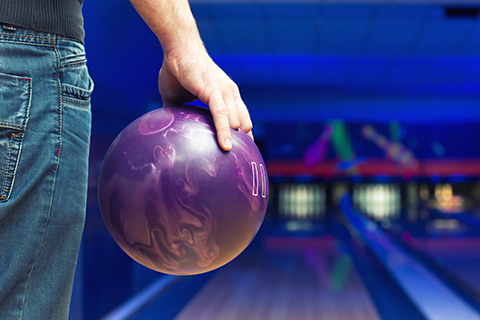 Closeup view of a man holding a bowling ball at 10 High Country Lanes in Boone, North Carolina, where guests staying at Xplorie participating properties can enjoy a free bowling game and shoe rental.
