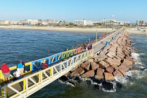 People enjoy fishing at 61st Street Fishing Pier in Galveston, Texas. Guests staying at Xplorie participating properties can enjoy a free admission each day of their stay