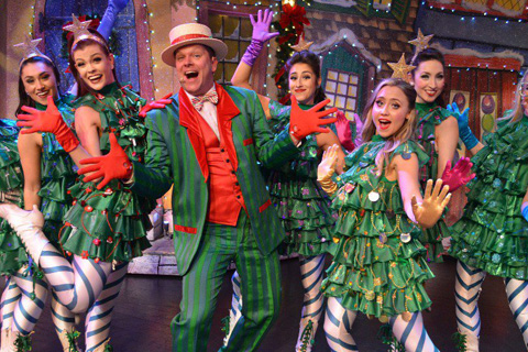 A group of happy performers in christmas outfits at the Alabama Theatre in North Myrtle Beach, South Carolina, which is available for free for guests staying at Xplorie participating properties.