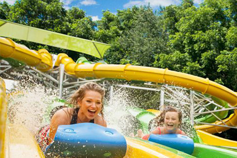 A little girl splashing down a water slide at Dollywood's Splash Country Water Park in Pigeon Forge, Tennessee, where guests staying at Xplorie participating properties can enjoy a free one-day ticket.
