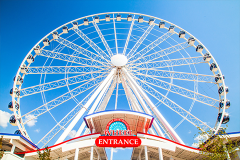 The Great Smoky Mountain Wheel stands against a blue sky in Pigeon Forge, Tennessee, where guests staying at Xplorie participating properties can enjoy a free admission.
