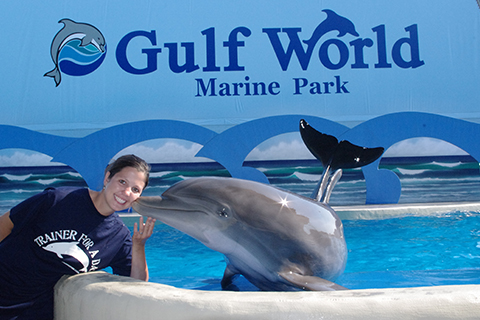 Dolphin kissing a trainer on the cheek at Gulf World in Panama City Beach, Florida. Guests at Xplorie participating properties can enjoy a free admission to Gulf World.