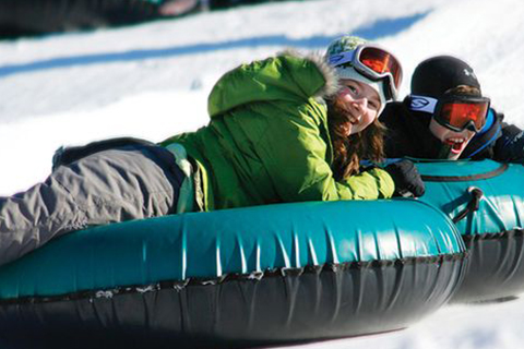 Children tubing down the Historic Fraser Tubing Hill in Fraser, Colorado, available for free at Xplorie participating properties.