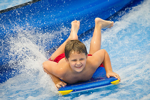 Young boy having a splashing good time at Myrtle Waves Water Park in Myrtle Beach, South Carolina, where Xplorie participating properties offer free admission.