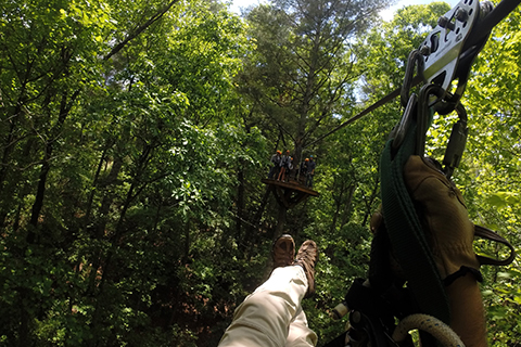 First person point of view of a person experiencing an exhilarating zipline adventure with Nacoochee Adventures in Helen, Georgia. Guests staying at Xplorie participating properties can enjoy a Moonshine Canopy Tour for free!