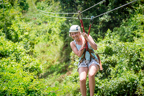 A woman begins her exciting zipline adventure from Raft One in Ducktown, Tennessee, where guests staying at Xplorie participating properties can enjoy a free Ocoee Zipline Canopy Tour.