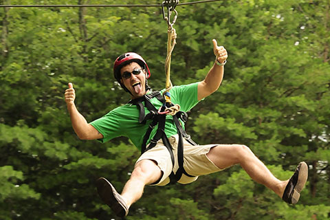 Man having fun ziplining at Sunburst Adventures in Clarkesville, Georgia, where guests staying at Xplorie participating properties can enjoy a free zipline adventure.