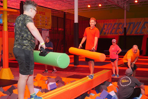 A boy with large foam rolls balancing at Urban Air Adventure Park in Destin, Florida, which is one of the many things guests can do for free when staying at an Xplorie participating property.