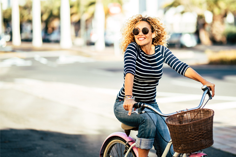 A woman enjoying her cruiser bike rental from Wheel Fun Rentals in Bend, Oregon, where guests staying at Xplorie participating properties can enjoy a free cruiser or multi-speed bike rental.
