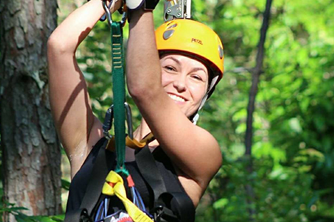 A woman begins her exciting zipline adventure from Wildwater in Ducktown, Tennessee, where guests staying at Xplorie participating properties can enjoy a free Ocoee River Canopy Tours Admission.