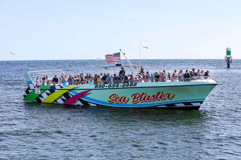 Group of people enjoying a ride on the Seablaster Sunset Dolphin Cruise boat in Destin, Florida, which is available for free for guests staying at Xplorie participating properties.